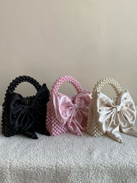 Soft satin, sweet bows, and pearl details 🎀✨ the perfect little bag to complete your look.